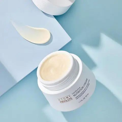 Pot de crème Nutrition Cream Atomy Absolute ouvert sur fond bleu